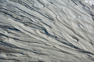 Mud flow from a mud volcano. Cracked mud surface. Mudflow texture with cracks.