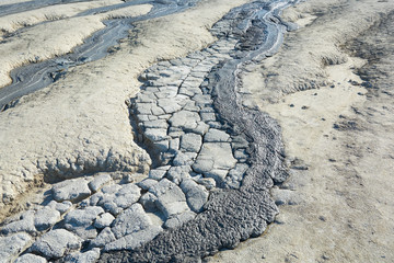 Mud flow from a mud volcano. Cracked mud surface. Mudflow texture with cracks.