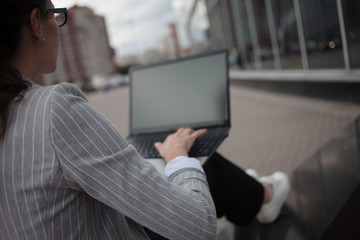 Young ambitious woman with a laptopworks on a laptop during a break.