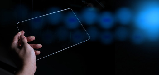Woman hand holding and touch screen smart phone, tablet or cellphone on abstract blurred bokeh dark...