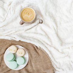 Cup coffee cappuccino and tasty sweet macaroons on light background with copy space. Winter Morning...