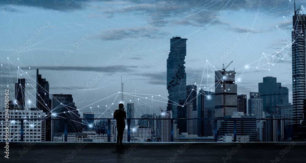 Aufkleber businessman standing using smart phone in modern space watching city night view.business wireless ne