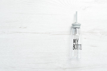 Water bottle with the inscription "My bottle". On a white wooden background. Flat lay.