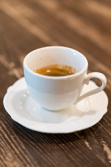 Cup of coffee with foam on wooden table, top view. A cup of coffee on wooden background. vertical photo