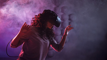 Virtual reality game. A girl in a VR helmet plays a game or explores the environment.