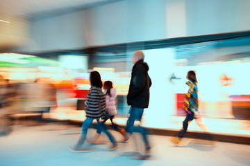 Large group of real people walking indoors, shopping spree