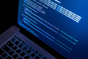 close up laptop computer screen with programming code creating
