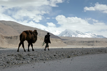 Mountainous landscape. A man with camel in Pamir mountains. Outskirts of Kashgar, Xinjiang, China,...