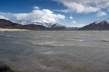 Mountainous landscape. View at Muztagh Ata Peak (7546 m) and Karakul Lake. Pamir mountains,...