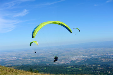 Paragliders in full flight over volcanoes of Puy de Dome