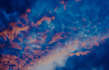 Sky during sunset with red clouds. A beautiful sunset with a reflection of red on the background of the setting sun. Background with clouds.