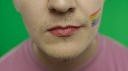 Bearded man with painted lips smiling on the camera. LGBT community. Transsexual