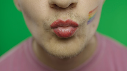 Bearded man with painted lips making a kiss. LGBT community. Transsexual