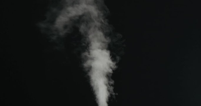 Slow motion water mist stream with wind over black background