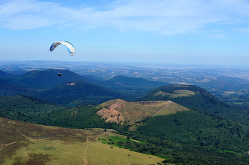 Paragliders in full flight over volcanoes of Puy de Dome