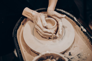 master makes a vase of clay, clay circle, close-up hands, mug of raw clay, hands made