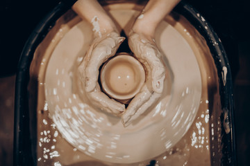 master makes a vase of clay, clay circle, close-up hands, mug of raw clay, hands made