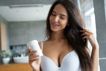 Young woman holding a bottle of vitamins