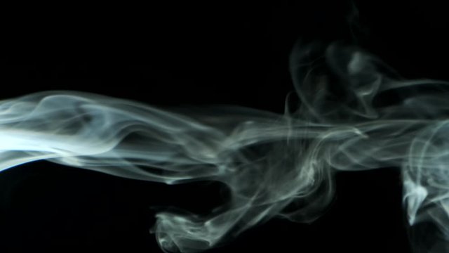 Vertical video screensaver - Thin trickle smoke rising graceful twists up on black background. Cigar smoke blowing from the left side. Great for editing, video without color correction and grading. 