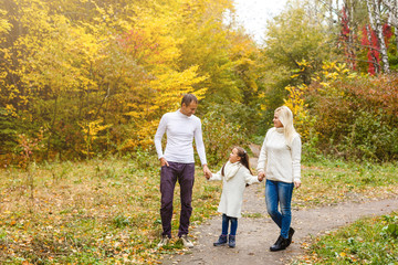 Naklejka na ściany i meble Family with child go in autumn park