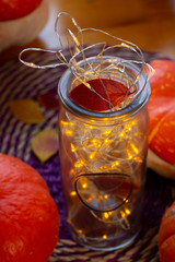 Lamp with little yellow lights, autumn leaves and pumpkins.