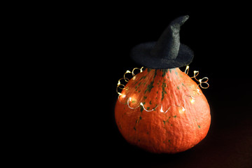 Halloween pumpkin with witches hat on dark background