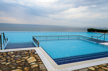 Infinity pool with crystal blue water view to sea  ocean