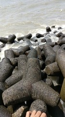 Fototapeta na wymiar water splashing on stones on the beach of Marine drive, Mumbai 