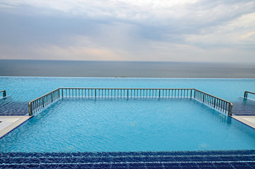 Fototapeta na wymiar Infinity pool with crystal blue water view to sea ocean