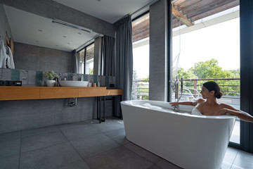 Pretty young woman taking a bubble bath