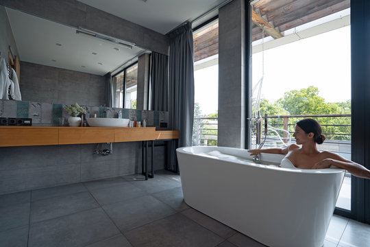 Pretty young woman taking a bubble bath