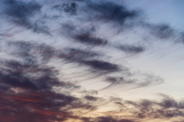 Sunset with cloudy sky, cirrus clouds, blues, oranges and yellows, nature background
