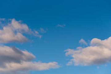 Crisp and clean nature background cumulus clouds in evening light, blue sky and white clouds