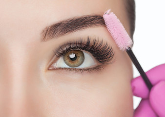 Beautiful Woman with long eyelashes in a beauty salon. Eyelash extension procedure. Lashes close up