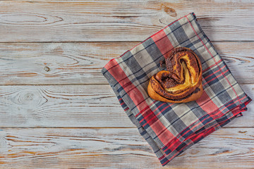 Cinnamon roll on a light wooden background.