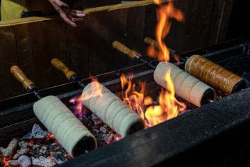 A chimney cake is baked over an open charcoal grill