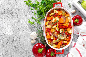 Roasted vegetables. Carrot, zucchini, onion and red pepper oven baked with herbs. Top view