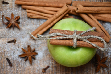 Top view: an apple, cinnamon sticks, star-anise, cloves and snow