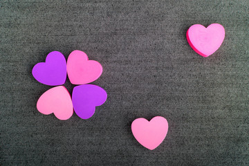 Obraz premium Six pink and mauve hearts on dark grey textile background, top view with space for text above, selective focus