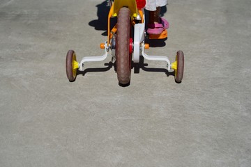 補助輪をつけて自転車の練習をする子供