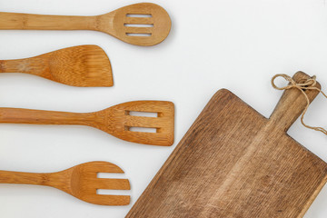 Wooden kitchen utensils on a white background, top view, horizontal orientation