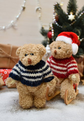 A Teddy Bear takes another one for a sledge drive on a background of a Christmas tree & boxes with Christmas presents