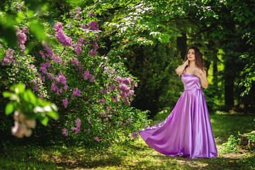 Obraz na płótnie Canvas Outdoor summer portrait of young beautiful happy woman in park or at nature. Joyous happy girl in purple dress