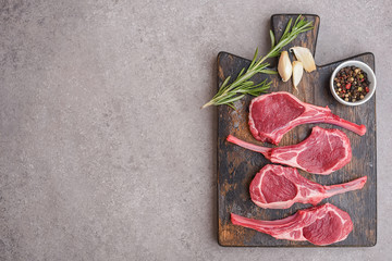Raw lamb chops on stone background