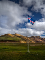 Icelandic flag against the backdrop of the Landmannalaugar mountains