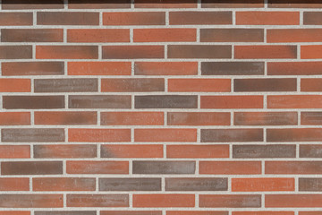Wall of red and brown brick and gray cement joints. Abstract cozy background for design and title.