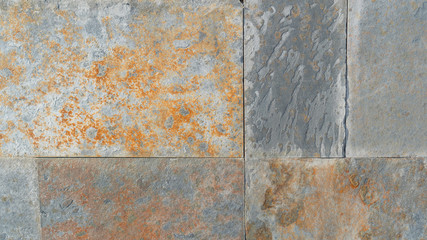 Old wall of damaged blocks covered with rust and corrosion. Colorful abstract background