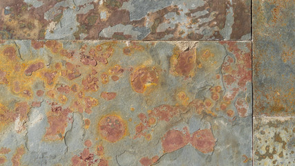 Old wall of damaged blocks covered with rust and corrosion. Colorful abstract background