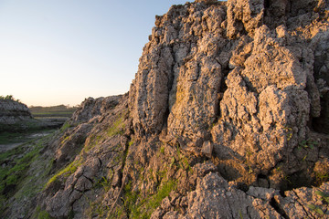 The curb erosion from storms. To indicate the layers of soil and rock.