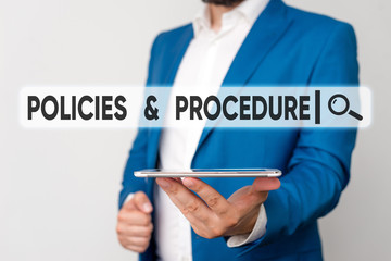 Text sign showing Policies And Procedure. Business photo showcasing list of rules defines customer and buyer rights Man in the blue suite and white shirt holds mobile phone in the hand